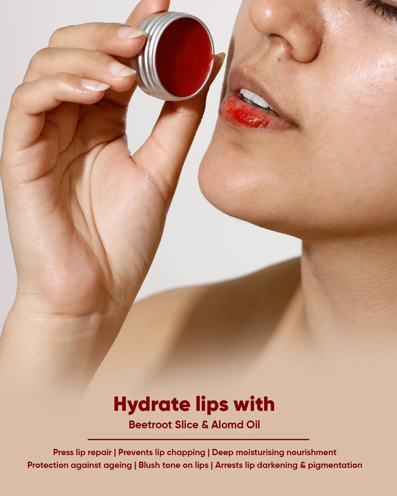 Person applying beetroot lip balm to their lips with product packaging.