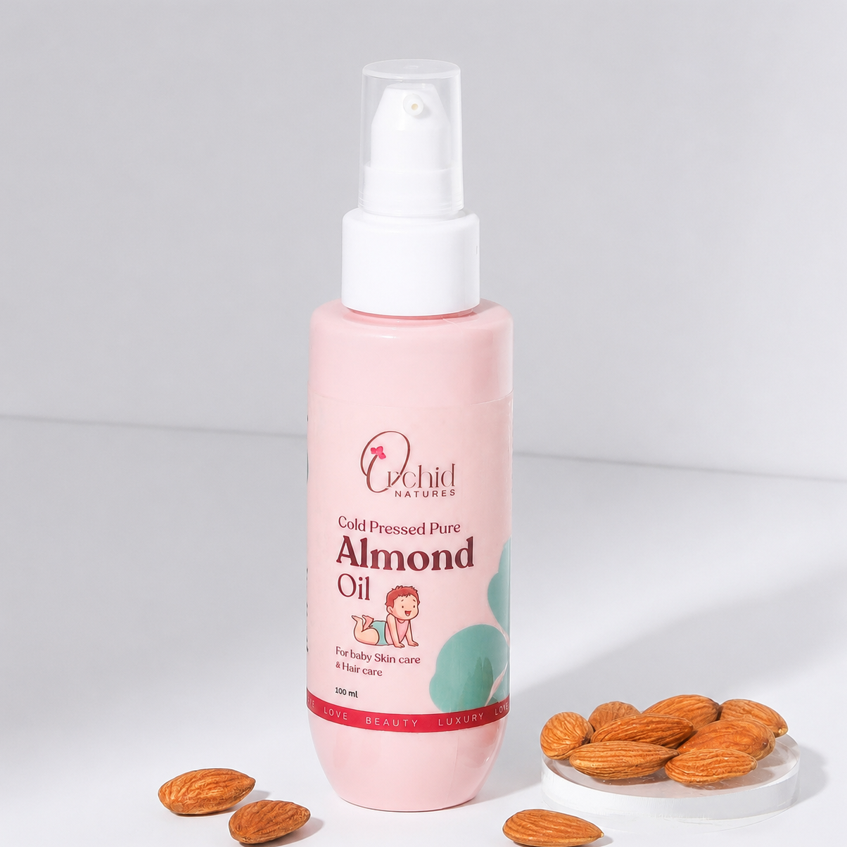 Pink bottle of almond oil with almonds on a white background